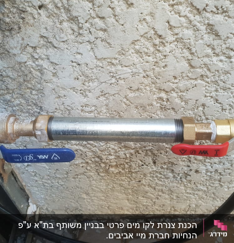 שני ברזים עם ידיות כחולה ואדומה על צינור מתכת
